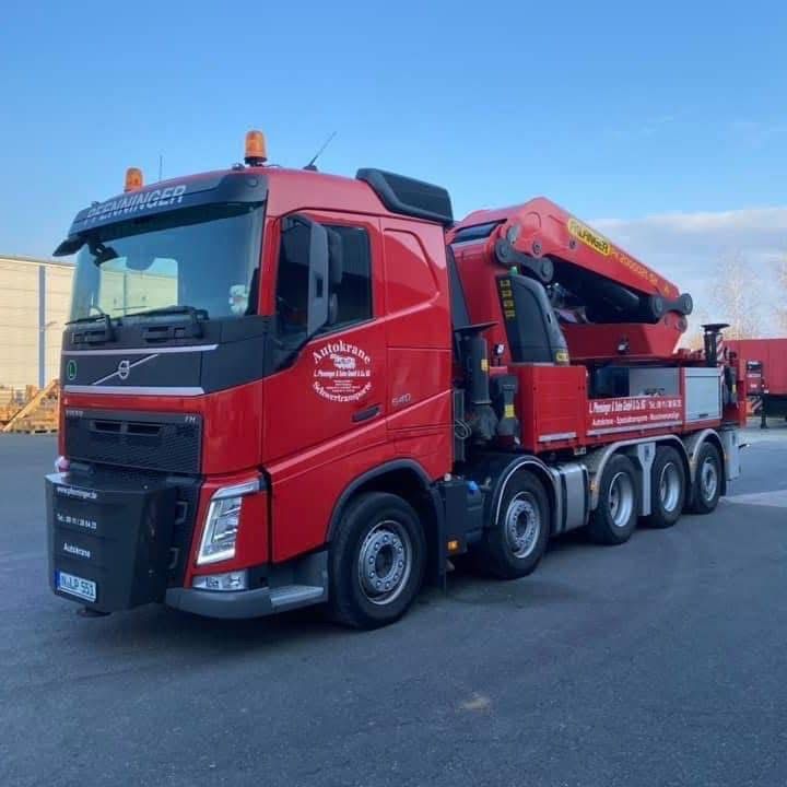 Pfenninger LKW mit großem Ladekran im Einsatz auf Baustelle.